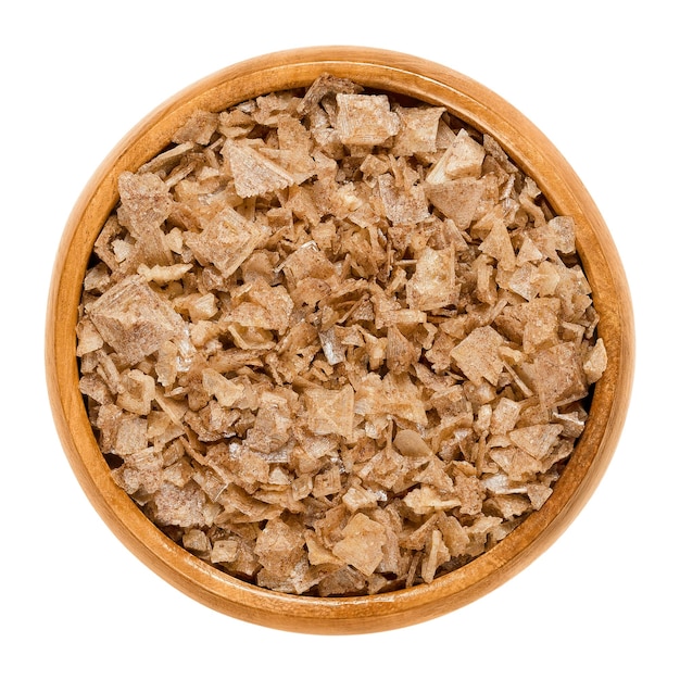 Smoked flat pyramid shaped sea salt in wooden bowl