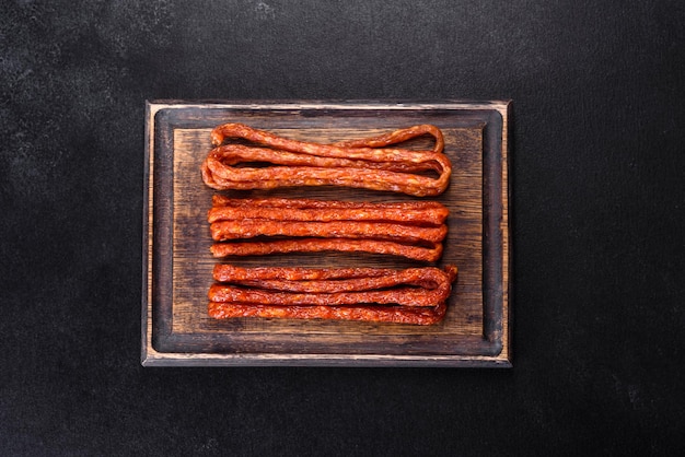 Smoked hunting sausages on a black stone background Top view Free copy space