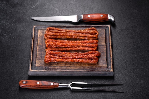 Smoked hunting sausages on a black stone background Top view Free copy space