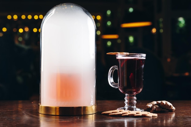 Фото Копченый старомодный коктейль и глинтвейн на столе на темном фоне