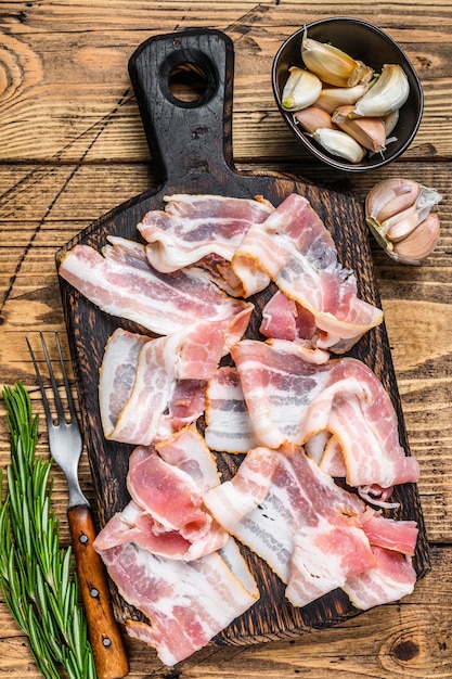 Smoked pork bacon slices on a wooden cutting board. 