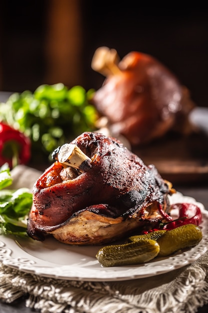 Smoked pork ham hock, pork knee served with pickled cucumbers and herbs.