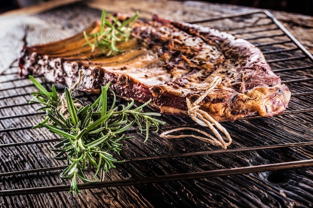 Smoked raw pork ribs and rosemary herbs on wooden board.