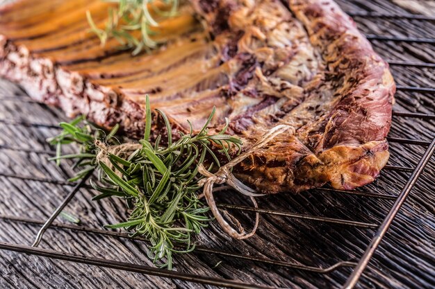 Smoked raw pork ribs and rosemary herbs on wooden board.