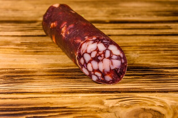 Smoked salami sausage on rustic wooden table