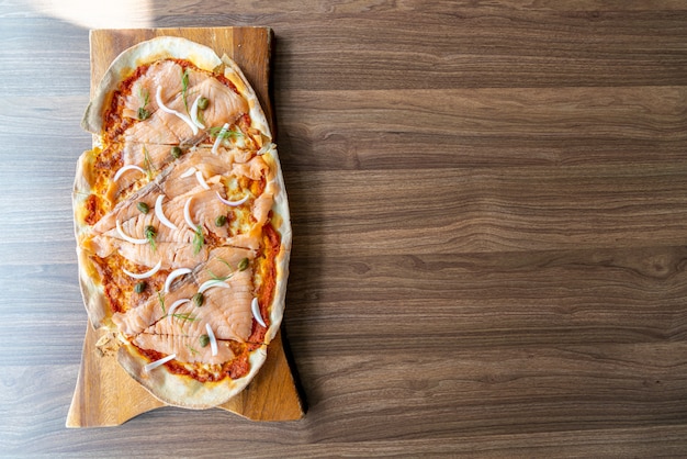 木の板にスモークサーモンのピザ