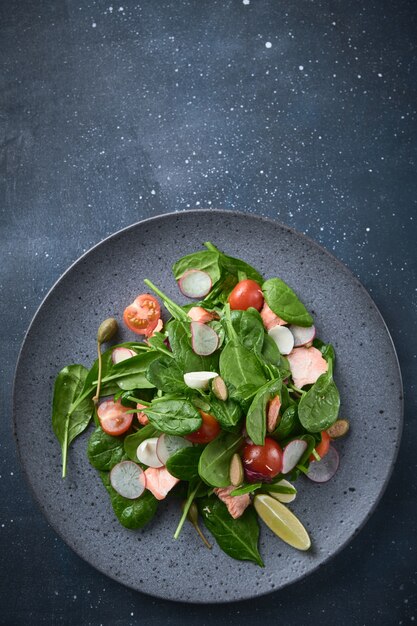 Салат с копченым лососем Здоровое питание Вкусный салат с редисом из красной рыбы и помидорами черри Вид сверху