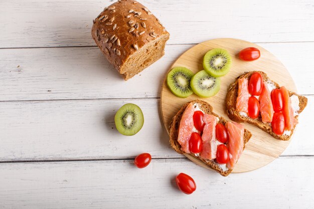 Panini al salmone affumicato con burro e pomodori ciliegia su bianco