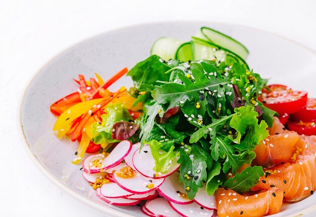 Smoked or salted salmon salad with cucumbers arugula peppers and radishes