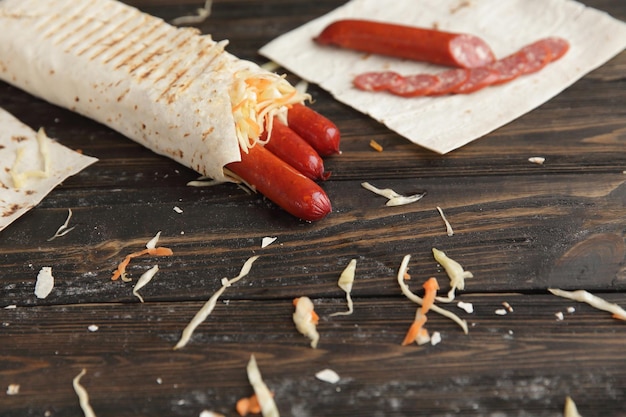 Smoked sausage in pita bread on a wooden table