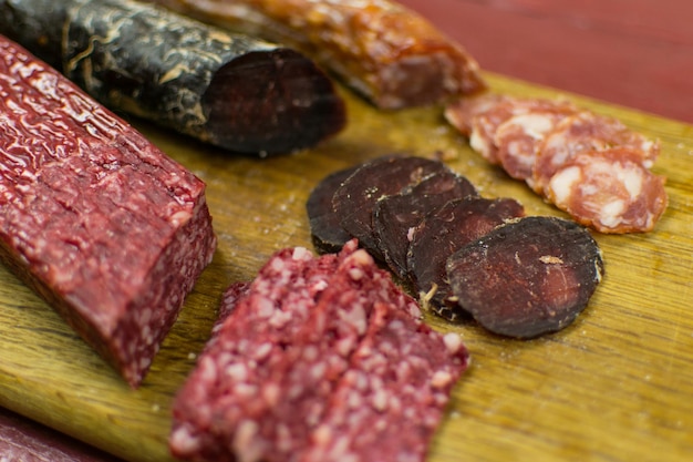 Smoked sausages are cut on a cutting board