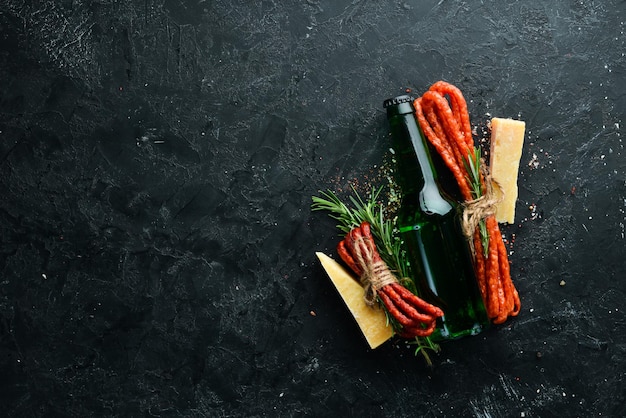 Salsicce affumicate con formaggio su fondo di pietra nera parmigiano kabanosy vista dall'alto spazio libero per il testo