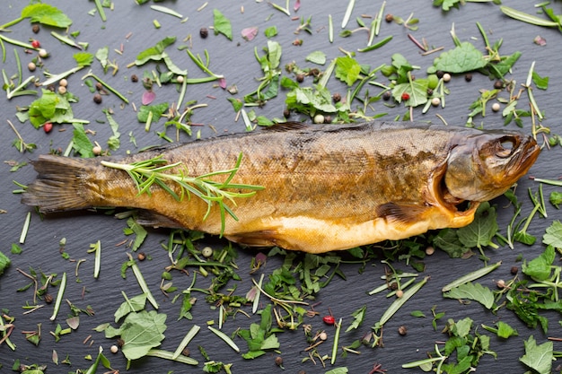 Smoked trout with spices on a stone tray.