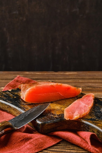 Smoked turkey breast on wooden cutting board with place for text