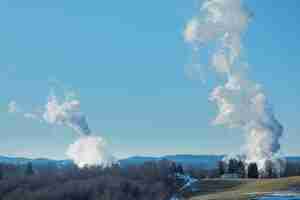 Photo smokestack emissions from coal fired powerplants photographed against a rural west virginia backdrop