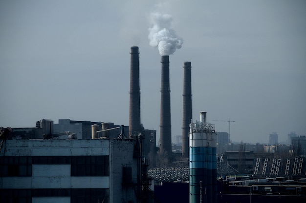 Smokestacks of industrial factory polluting air under smog in the sky