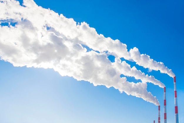 Smoking chimneys against the blue sky