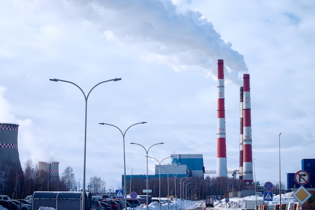 Smoking chimneys of factory, on background of sky with clouds in the city