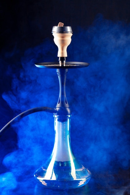 Smoking hookah on black with color fog copy space