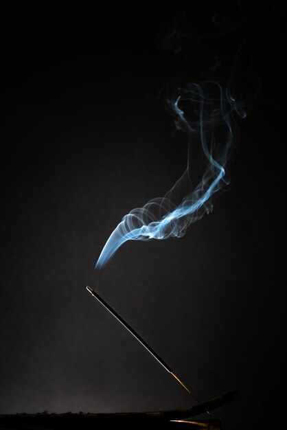 Smoking incense stick with relaxing smoke rising up.