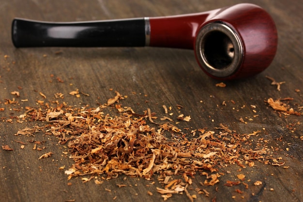 Photo smoking pipe and tobacco on wooden table closeup