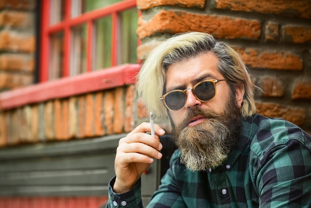 Smoking place bearded man in glasses relax with cigarette brutal mature hipster smoking cigarette bad habits concept harmful for your health smoke nicotine addicted he is heavy smoker