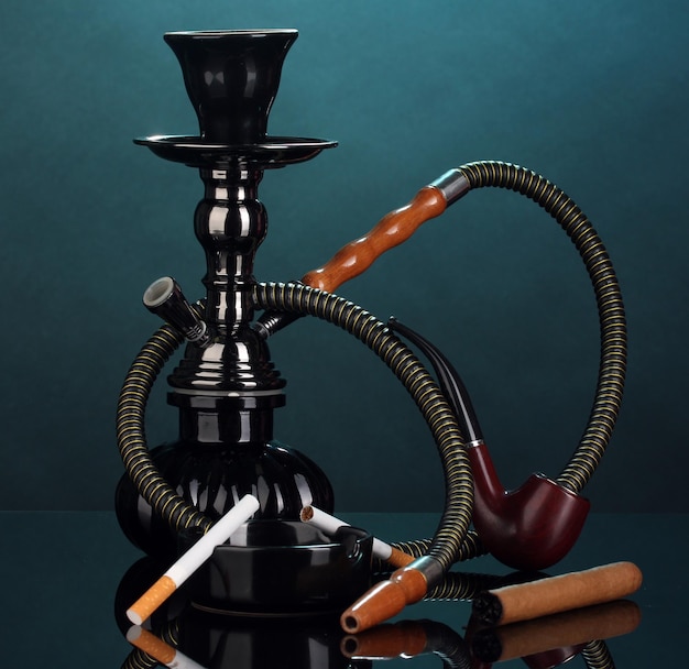 Photo smoking tools a hookah cigar cigarette and pipe on blue background