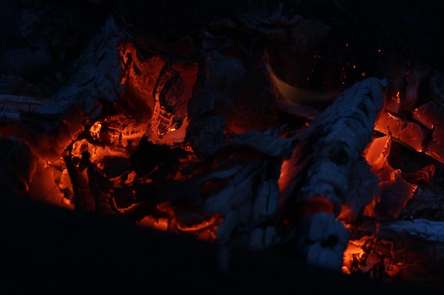 Photo smoldered logs burned in vivid fire close up atmospheric background with flame