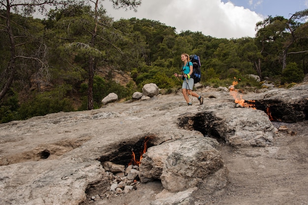 Smoldering campfires in front of female tourist