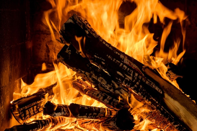 Тлеющее деревянное бревно в огне у камина в помещении дома