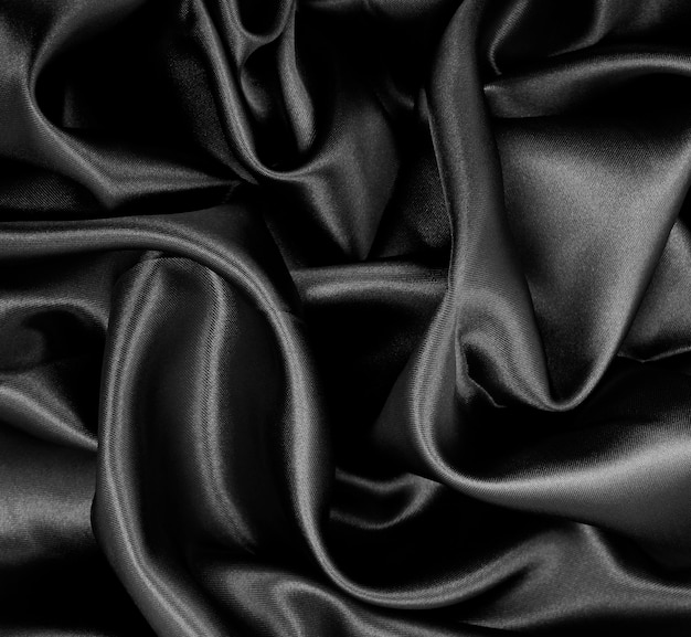 Smooth elegant black silk or satin texture as abstract background Luxurious background design
