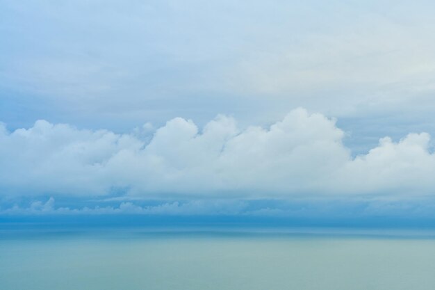 A smooth line of thick clouds on the horizon above the sea.