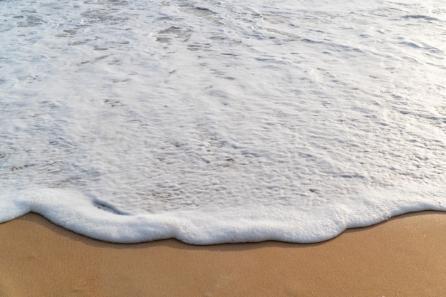 Foto onda liscia a spiaggia di sabbia bianca