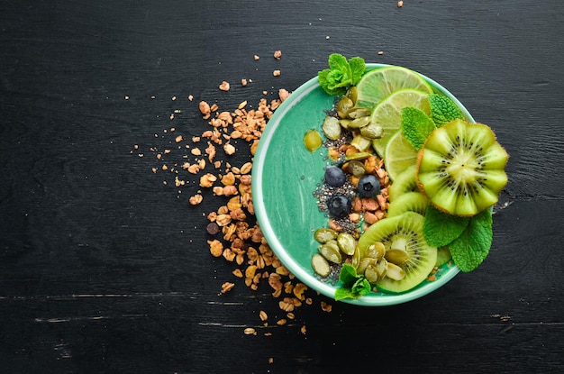 Smoothie bowl with green spirulina kiwi mint and pumpkin seeds Breakfast Top view Free space for your text