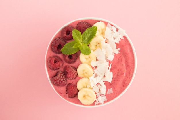 Smoothie bowl with raspberries, banana and coconut chips