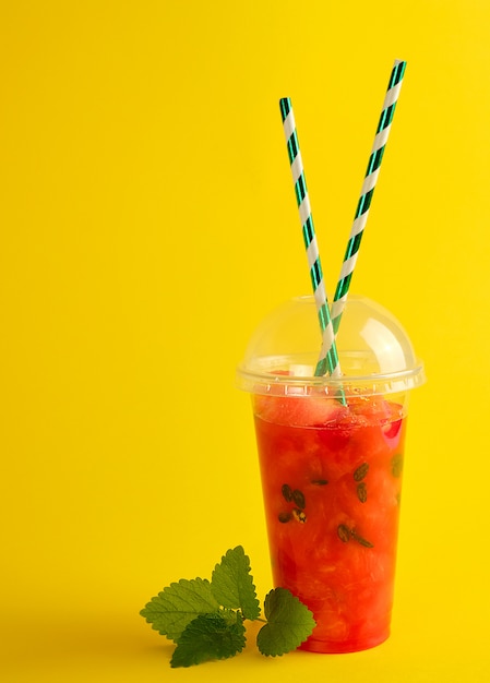 Smoothie from ripe red watermelon in a plastic cup