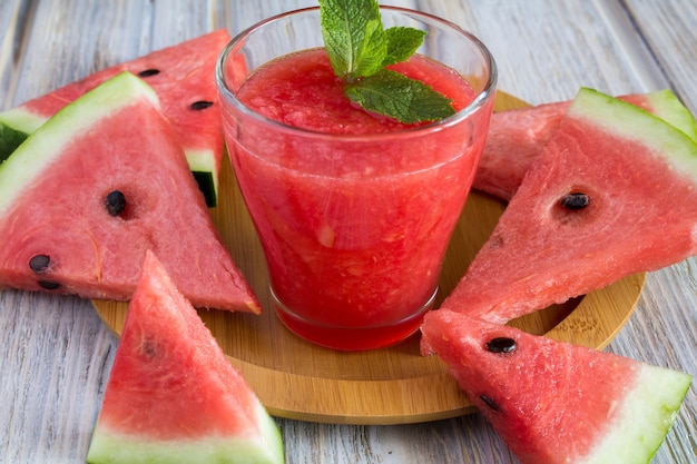 Smoothie from watermelon on the round brown cutting board