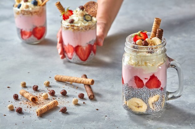 Smoothie in glasses with fruits strawberry, banana, blueberry, oat flakes and chia