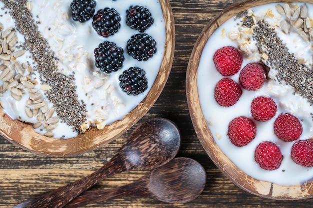 Smoothie in kokoskom met bramen frambozen havermout zonnebloempitten en chia zaden voor het ontbijt close-up Het concept van gezond eten superfood Bovenaanzicht