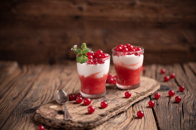 Smoothie made of red frozen berries in different small glasses close up