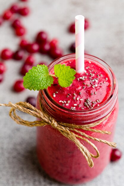 Smoothie, pink juice on grey .