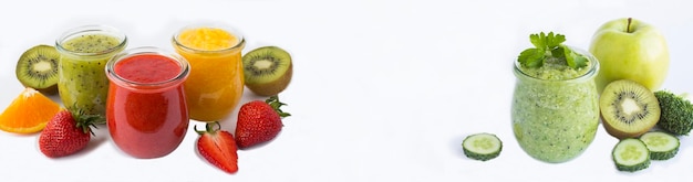 Photo smoothie or puree with fruit berry and vegetable in the small glass jars on the white background copy space banner