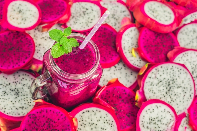 Smoothie of red organic dragon fruit and pieces of dragon fruit