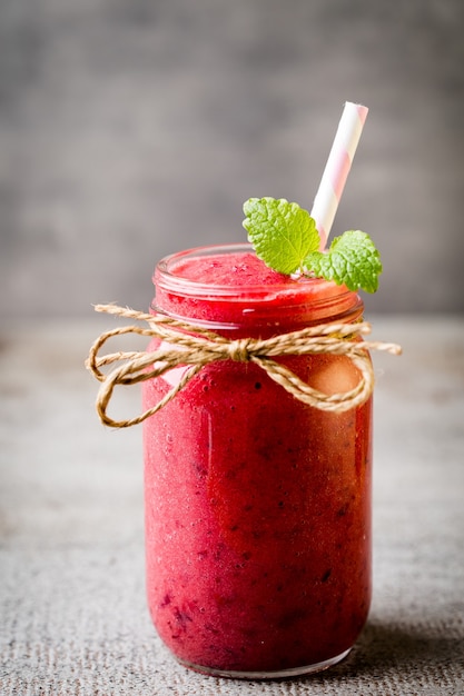 Smoothie, roze sap op het grijze oppervlak.