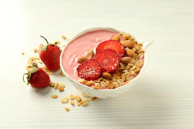 Smoothie with different ingredients on white wooden background