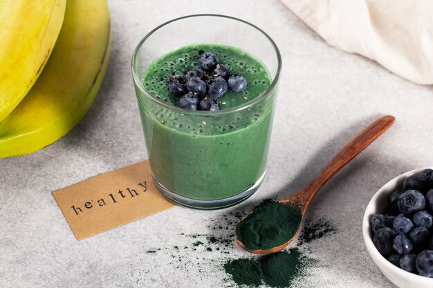 Foto frullato con spirulina e banana in un bicchiere