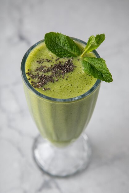 Smoothiedrank en groen sap op een grijze achtergrond Gezonde groentedrank