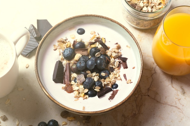 Smoothiekom met yoghurt, verse bessen en ontbijtgranen