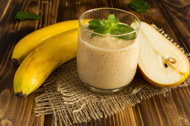 smoothies bananas and pear on the wooden background
