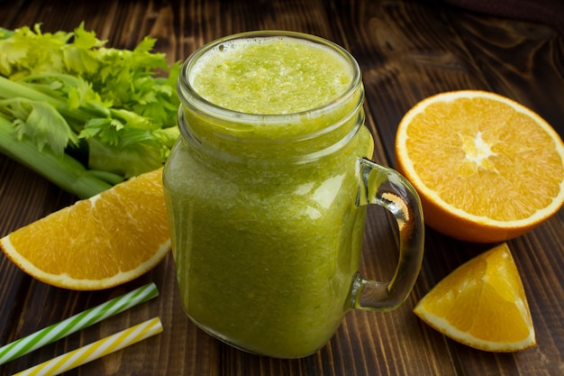 Smoothies met sinaasappel en selderij op de bruine houten tafel